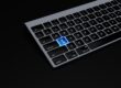 a black keyboard with a blue button on it