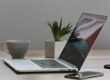 Free Minimalist home office desk with laptop, smartphone, and plant for a modern work environment. Stock Photo