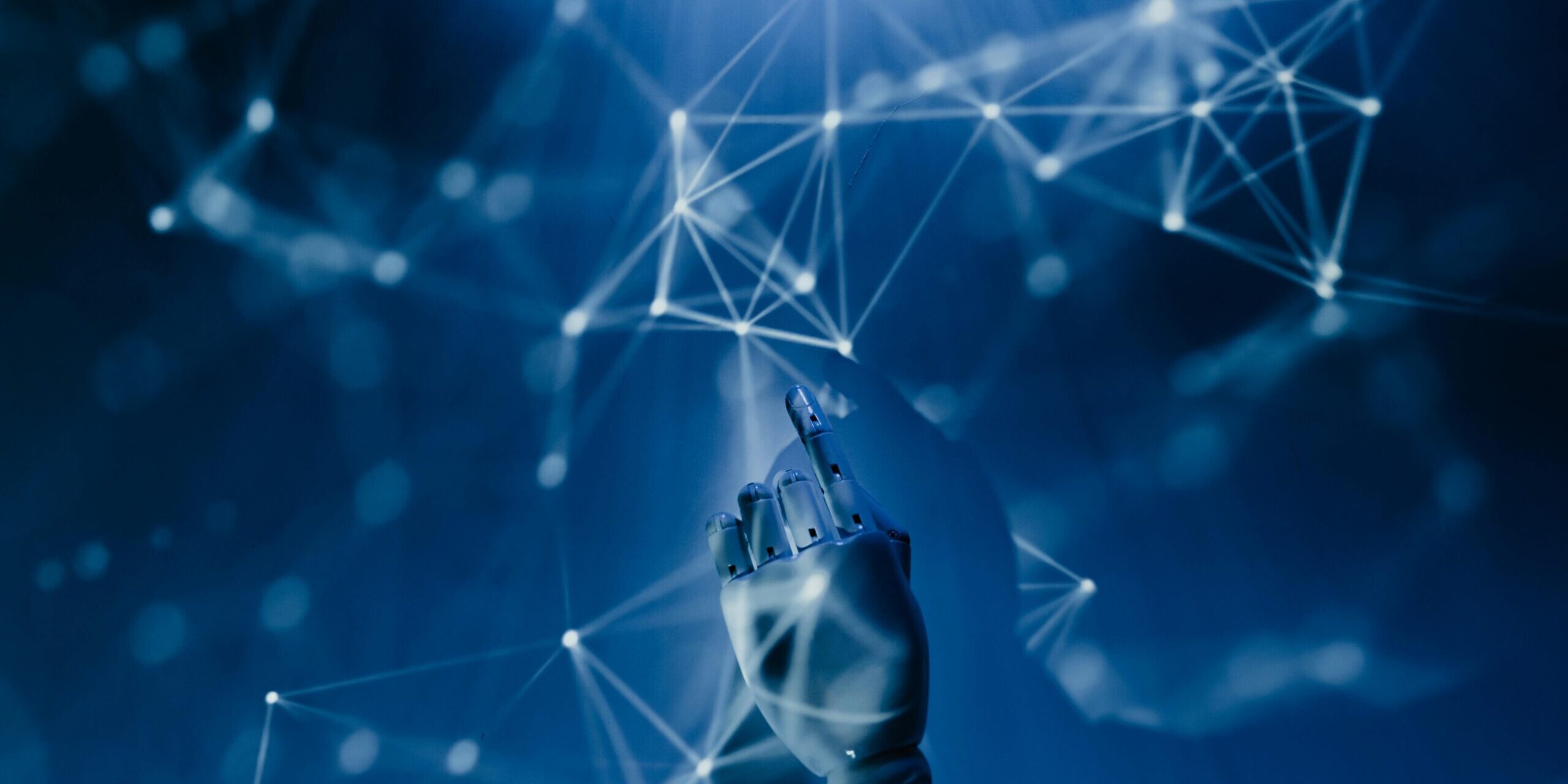AI-Demystified_-What-to-Know-About-the-Current-Tools-on-the-Market-in-2025-scaled.jpg Free A robotic hand reaching into a digital network on a blue background, symbolizing AI technology. Stock Photo