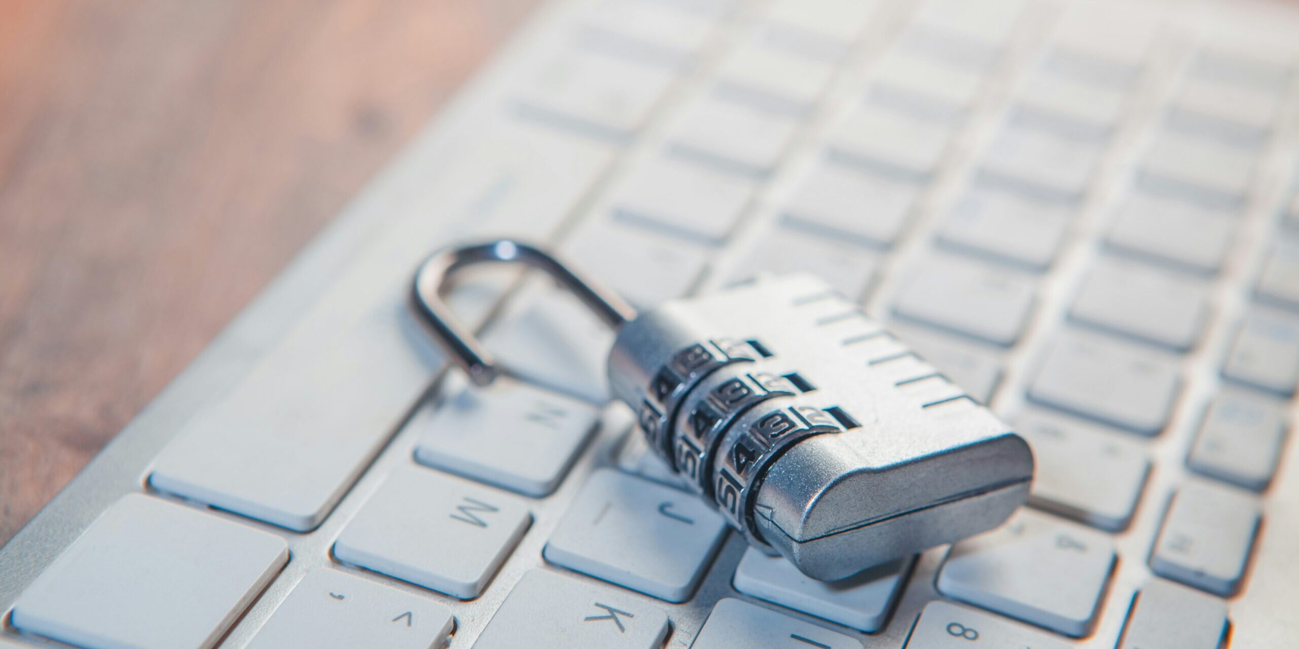 A combination lock rests on a computer keyboard.