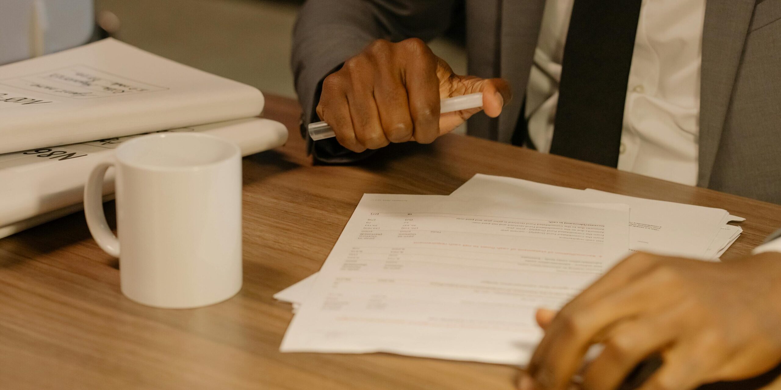 pexels-cottonbro-8369207-scaled.jpg Free Close-up of a businessman holding and reviewing documents on a wooden desk. Stock Photo