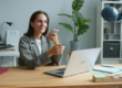 lady holding phone while working on a laptop
