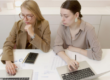 two women with laptops